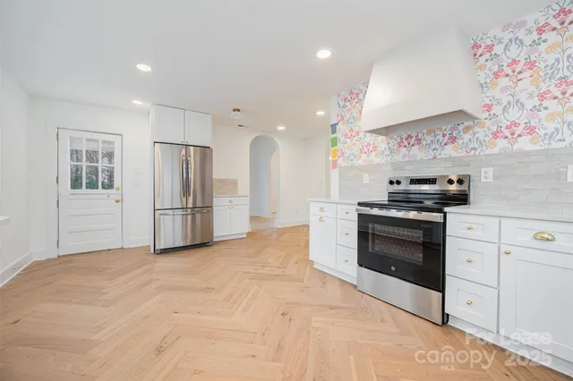 a kitchen with stainless steel appliances kitchen island granite countertop a refrigerator and a stove top oven