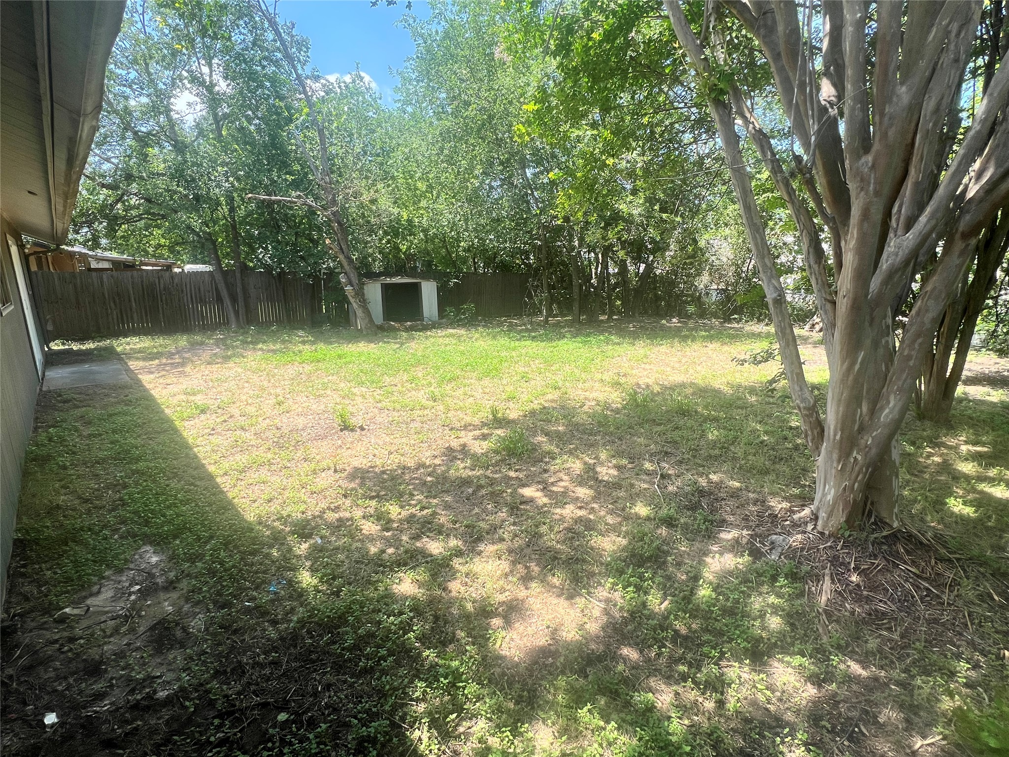 4620 Button Bend Road Austin, TX 78744 - Photo 21 of 22 A spacious, fenced backyard offers mature trees and a convenient storage shed.