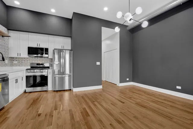 a view of a kitchen with a sink a kitchen counter top space stainless steel appliances and cabinets