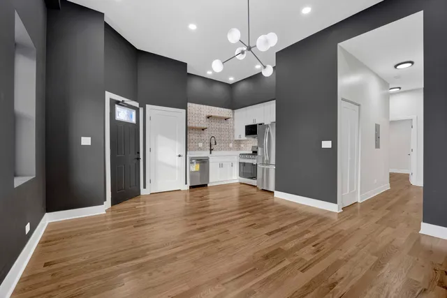 a view of a kitchen with a refrigerator wooden floor and a kitchen