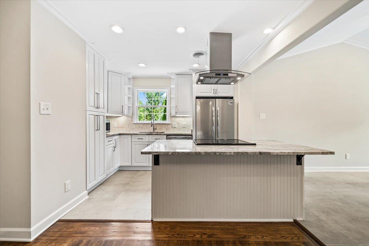 170 South Greer Street Memphis, TN 38111 - Photo 13 of 35 Contemporary kitchen featuring white cabinetry, a granite countertop island with a cooktop, a stainless steel range hood, and recessed lighting