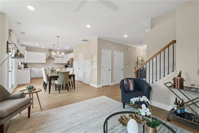 a view of a dining room and livingroom with furniture wooden floor a chandelier