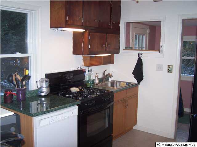 45 Hilltop Road Howell, NJ 07731 - Photo 3 of 3 a kitchen with stainless steel appliances granite countertop a sink stove and cabinets