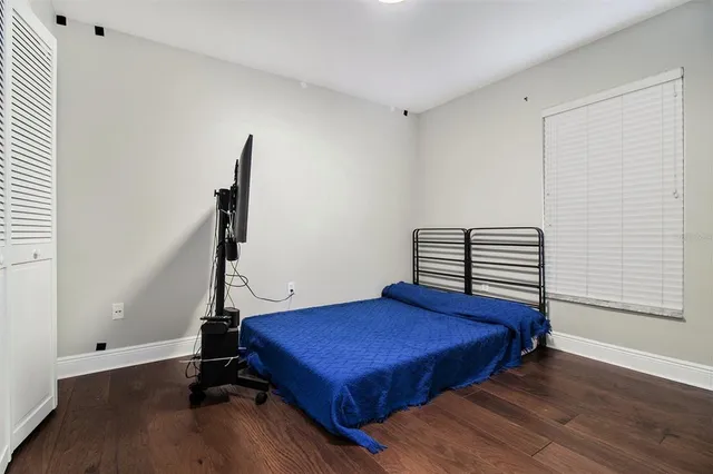 a bedroom with a bed and wooden floor