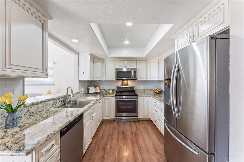 1013 London Circle Placentia, CA 92870 - Photo 20 of 45 a kitchen with granite countertop stainless steel appliances a sink stove top oven and refrigerator