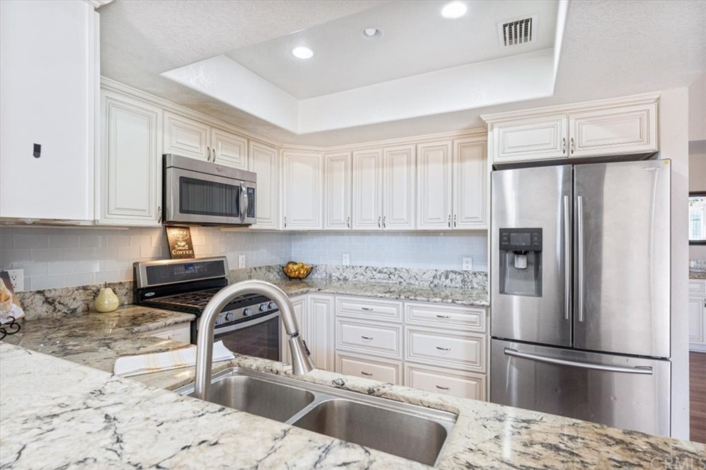 1013 London Circle Placentia, CA 92870 - Photo 28 of 45 a kitchen with a refrigerator a microwave and cabinets