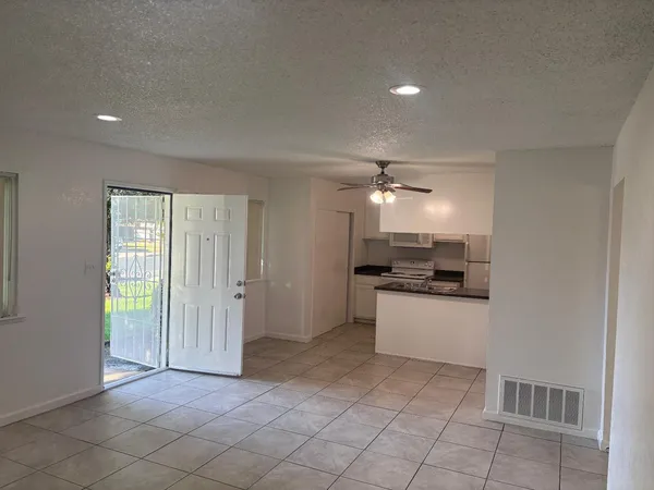 a kitchen with granite countertop a stove a sink and a refrigerator