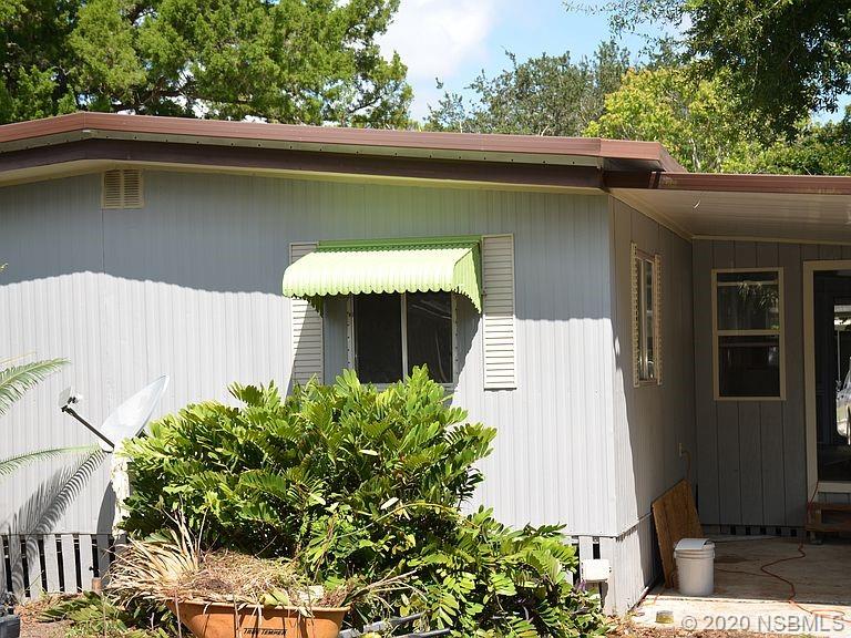 118 Charles Street Edgewater, FL 32141 - Photo 3 of 8 a front view of a house with a garden