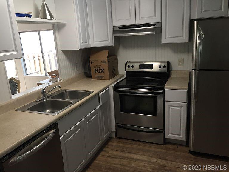 118 Charles Street Edgewater, FL 32141 - Photo 4 of 8 a kitchen with a stove microwave and fridge