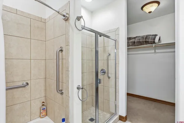 a bathroom with a granite countertop sink a mirror and a shower