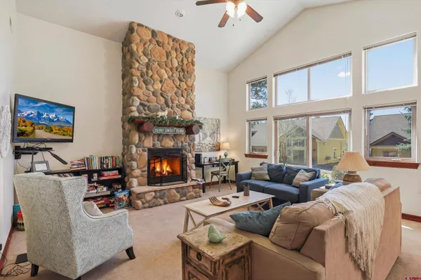 a living room with furniture a flat screen tv and a fireplace