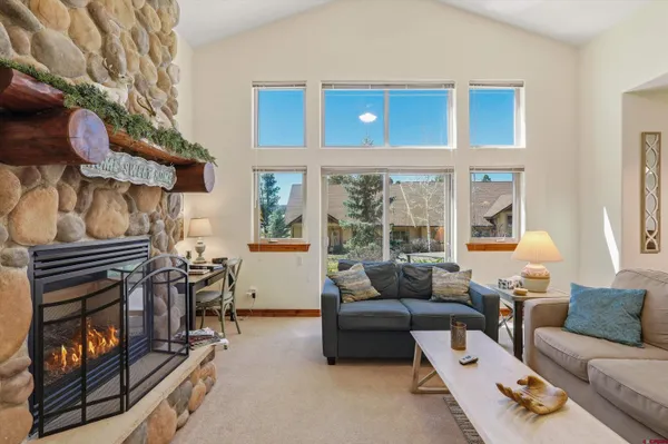 a living room with furniture kitchen view and a chandelier