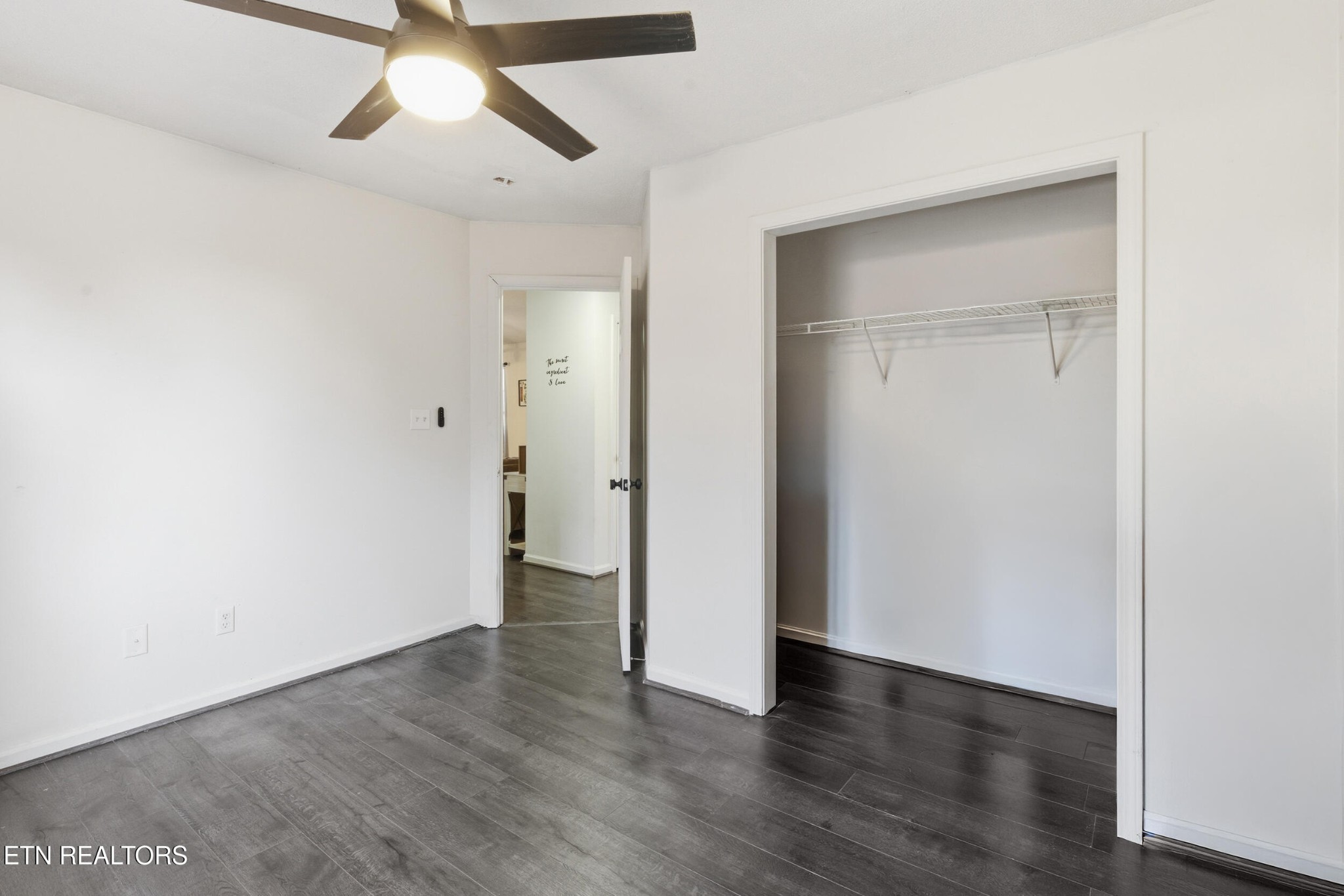7712 Ralph Youmans Road Corryton, TN 37721 - Photo 18 of 33 an empty room with wooden floor and ceiling fan