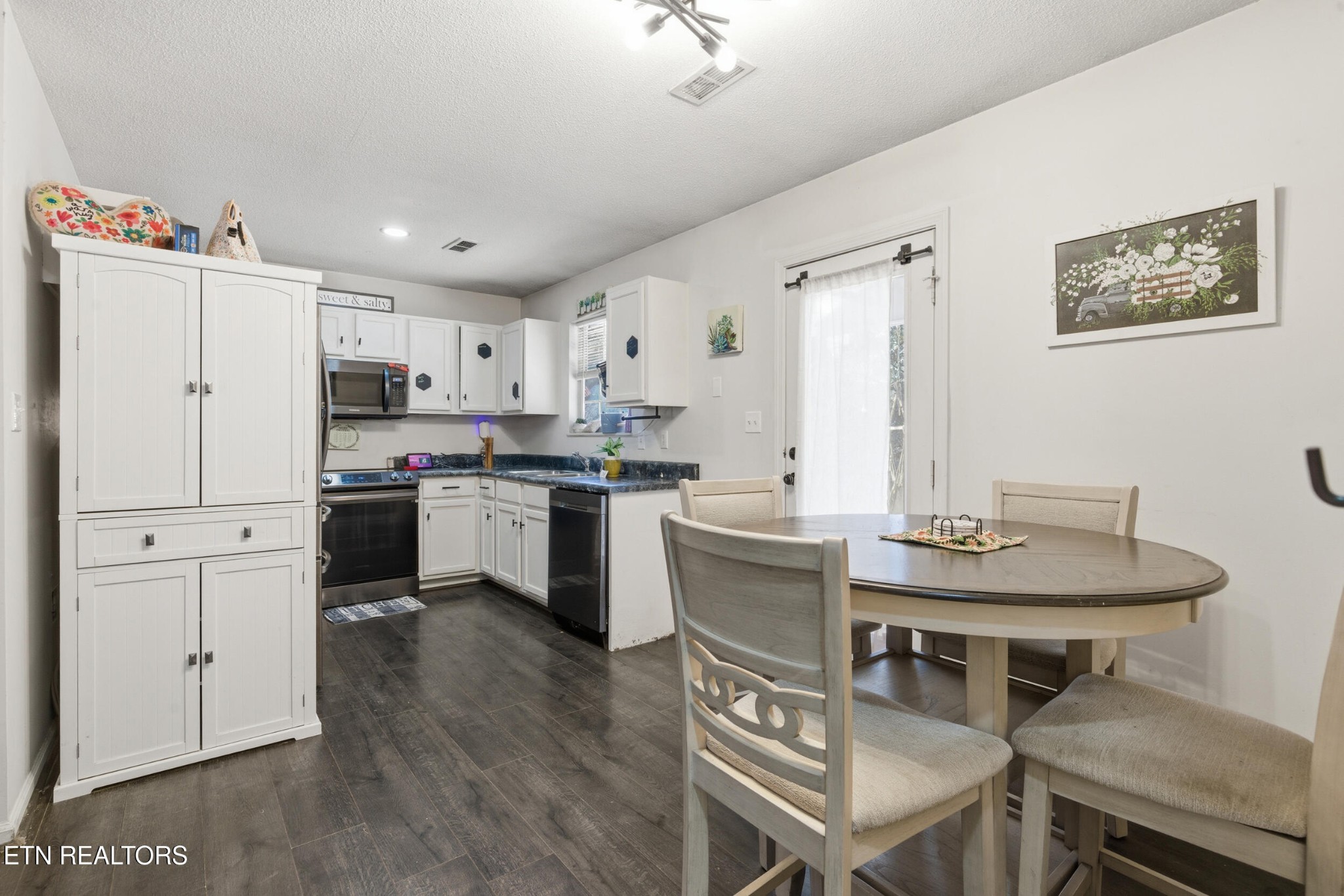 7712 Ralph Youmans Road Corryton, TN 37721 - Photo 8 of 33 a kitchen with a table chairs refrigerator and cabinets