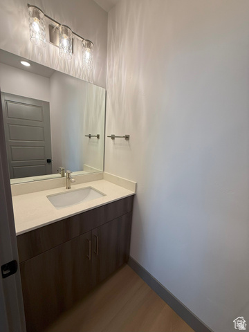8087 South 615 East, Unit 3 Sandy, UT 84070 - Photo 7 of 23 Vanity with an integrated sink, light-toned countertop, and wood-finish cabinetry
