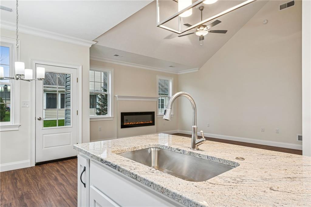 406 Kastner Street Ligonier, PA 15658 - Photo 15 of 35 a kitchen with a granite countertop sink with stainless steel appliances wooden floor and a fireplace