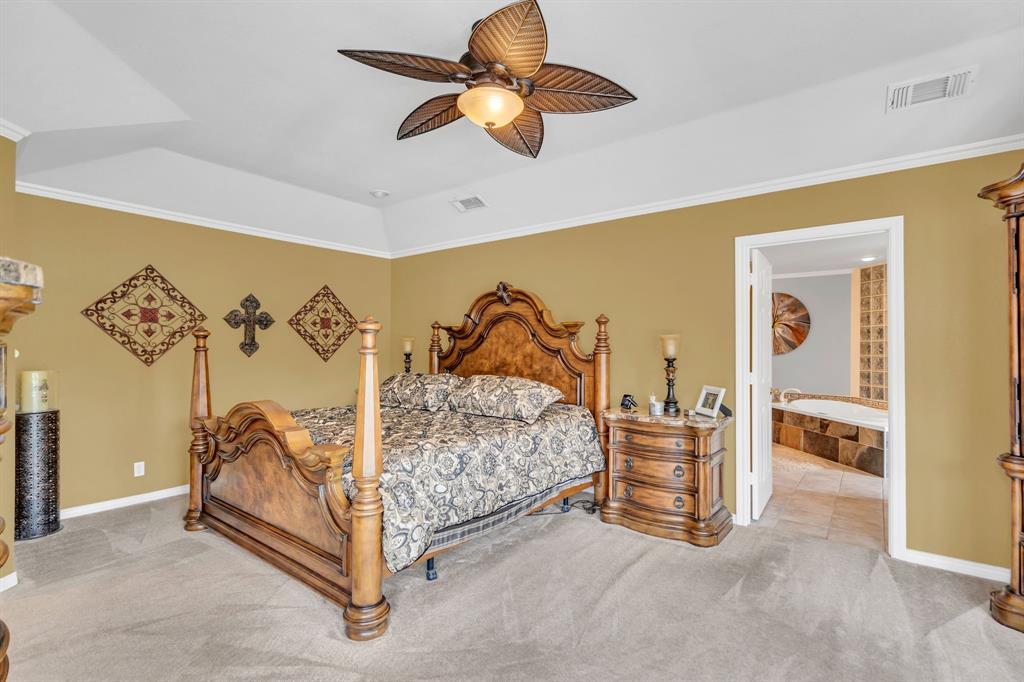50 Buckingham Lane Allen, TX 75002 - Photo 24 of 39 Carpeted bedroom with ornamental molding, a raised ceiling, a ceiling fan, and connected bathroom
