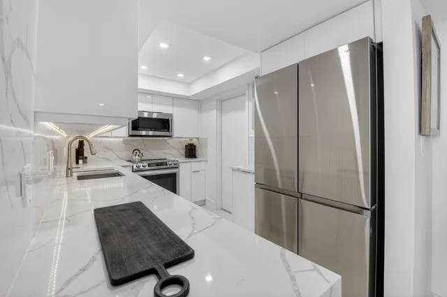 a kitchen with stainless steel appliances granite countertop a sink and a stove