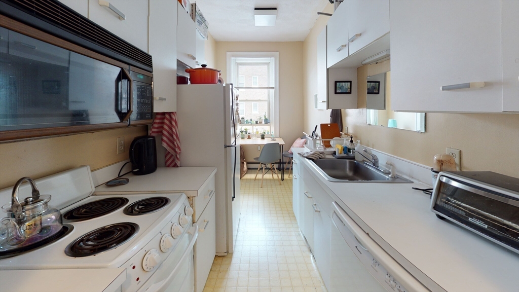 a kitchen with a sink a stove and cabinets