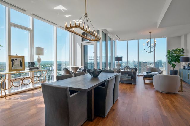 a kitchen with kitchen island granite countertop a oven a sink a counter space and a dining table