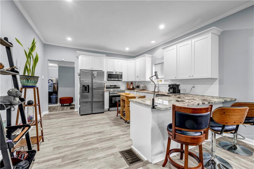 545 Grant Street Southwest Atlanta, GA 30315 - Photo 7 of 18 a kitchen with stainless steel appliances granite countertop a stove refrigerator and cabinets