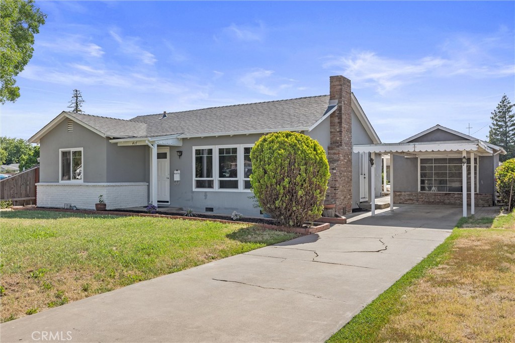 a front view of a house with a garden and yard