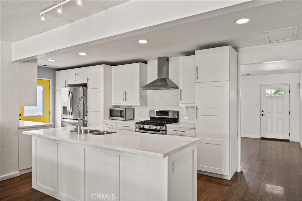 417 Jefferson Street Willows, CA 95988 - Photo 12 of 32 a kitchen with stainless steel appliances a refrigerator a stove a sink and white cabinets with wooden floor