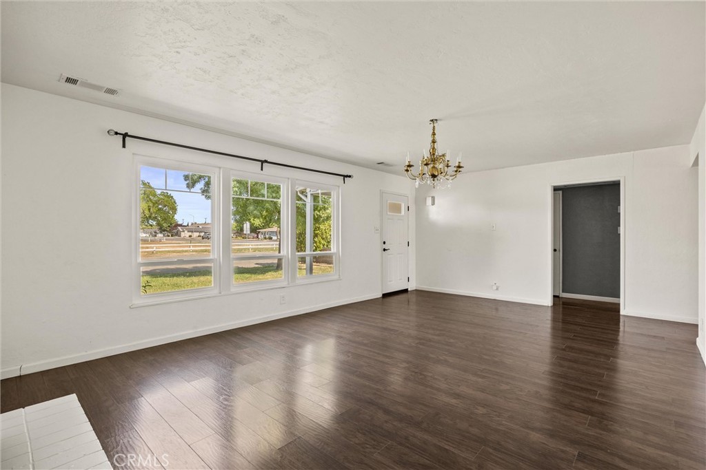 417 Jefferson Street Willows, CA 95988 - Photo 14 of 32 an empty room with wooden floor chandelier and windows