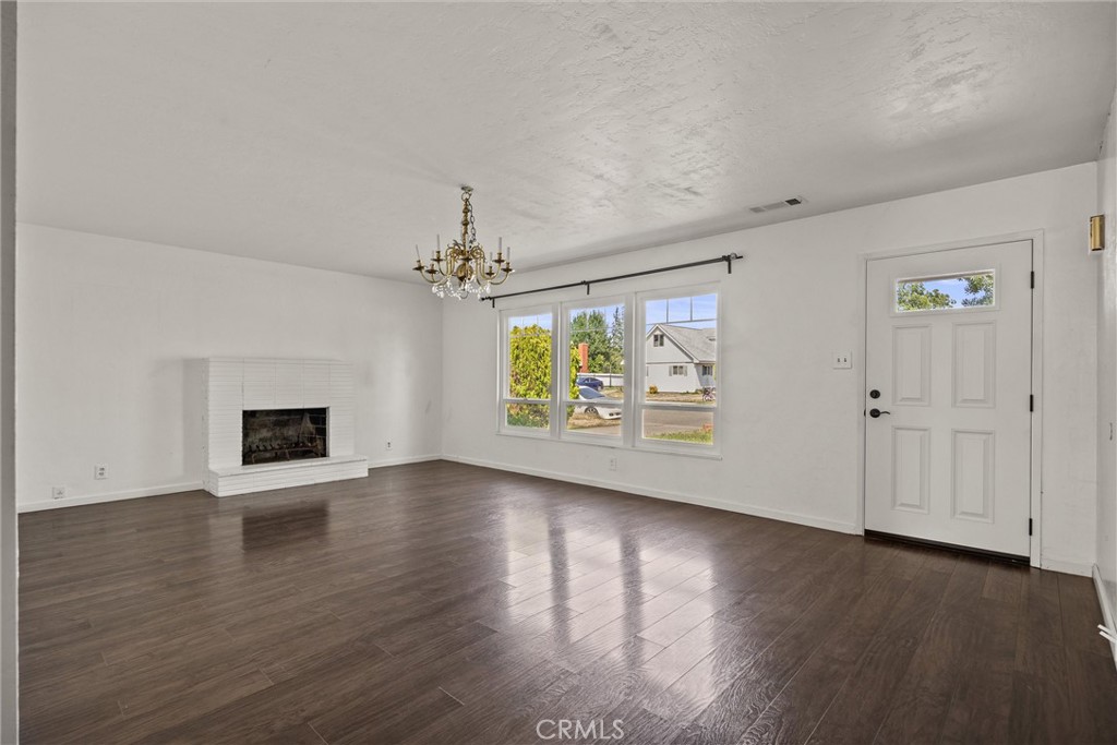 417 Jefferson Street Willows, CA 95988 - Photo 9 of 32 an empty room with wooden floor fireplace and window