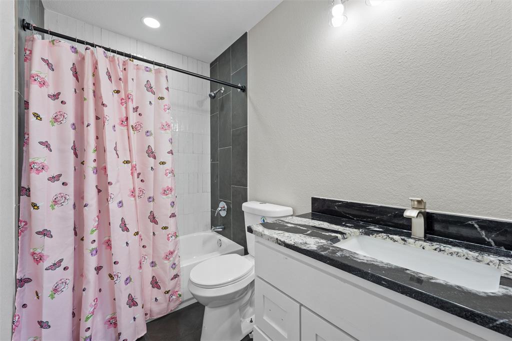 145 129a Marlin, TX 76661 - Photo 20 of 38 a bathroom with a granite countertop sink a toilet and a shower curtain