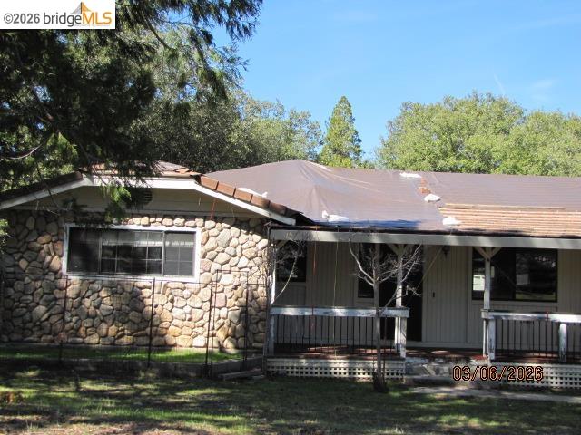 20280 Little Valley Road Groveland, CA 95321 - Photo 11 of 24 View of front facade featuring covered porch and stone siding
