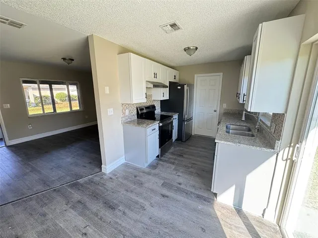 a kitchen with a refrigerator and a stove top oven