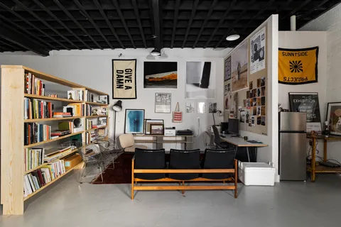 a living room with furniture a rug and a bookshelf
