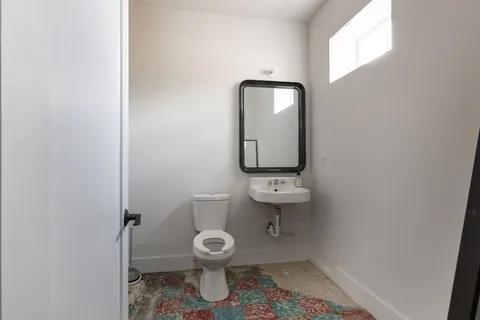 a bathroom with a toilet sink and mirror