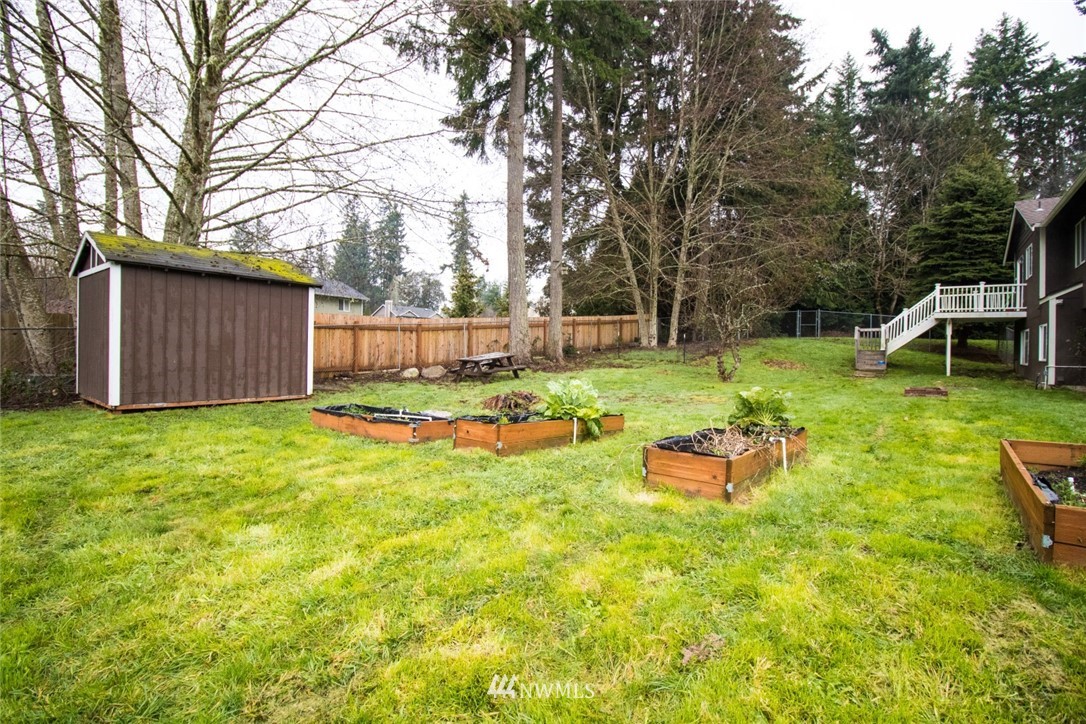 214 Fern Meadows Loop Southeast Port Orchard, WA 98366 - Photo 19 of 23 a view of a backyard with table and chairs and a fire pit