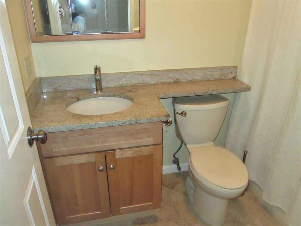 32 Lantern Lane, Unit 8 Dracut, MA 01826 - Photo 12 of 14 a bathroom with a granite countertop toilet sink and mirror