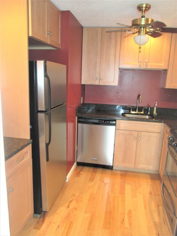 32 Lantern Lane, Unit 8 Dracut, MA 01826 - Photo 4 of 14 a kitchen with stainless steel appliances granite countertop a refrigerator a sink a stove and white cabinets