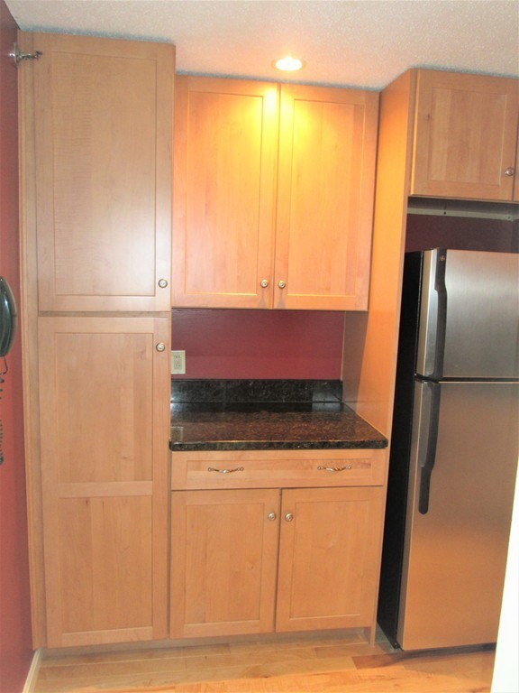 32 Lantern Lane, Unit 8 Dracut, MA 01826 - Photo 5 of 14 a kitchen with granite countertop a refrigerator and a sink