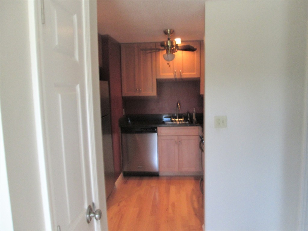 32 Lantern Lane, Unit 8 Dracut, MA 01826 - Photo 6 of 14 a kitchen with a refrigerator and cabinets