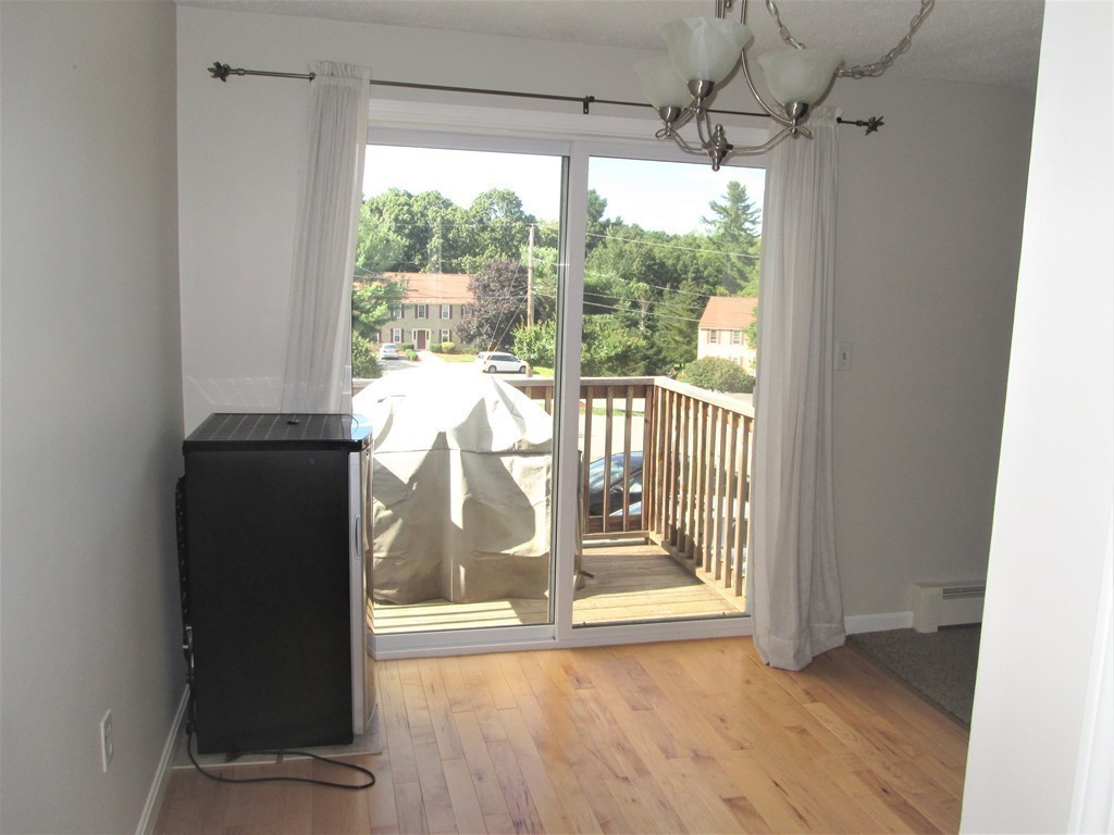 32 Lantern Lane, Unit 8 Dracut, MA 01826 - Photo 8 of 14 a view of an empty room with wooden floor and a window