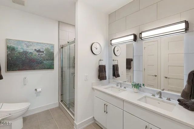a bathroom with a double vanity sink mirror and toilet