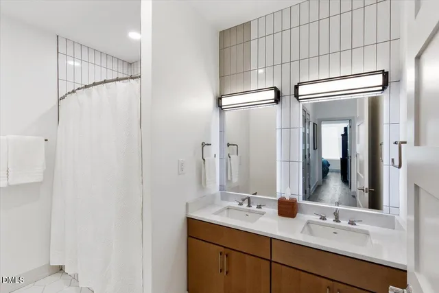 a bathroom with a double vanity sink and mirror
