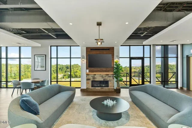 a living room with furniture a flat screen tv and a large window