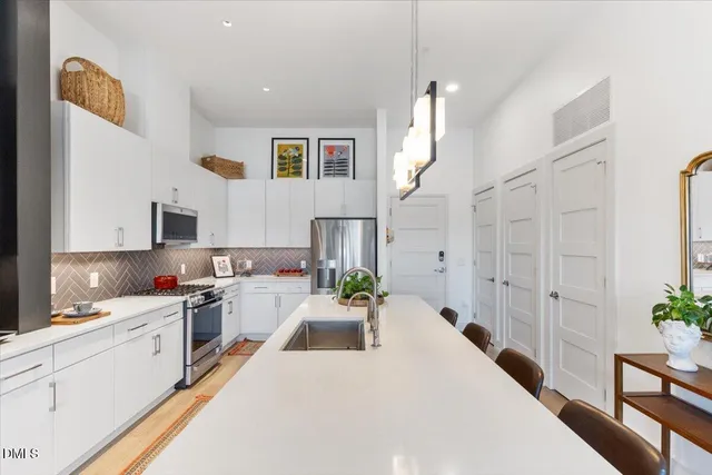 a kitchen with stainless steel appliances kitchen island granite countertop a sink stove and cabinets