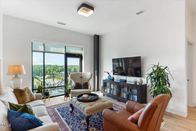 a living room with furniture a flat screen tv and a large window