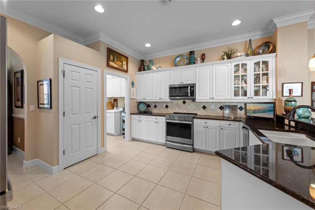20042 Buttermere Court Estero, FL 33928 - Photo 14 of 47 a kitchen with stainless steel appliances a refrigerator sink and cabinets