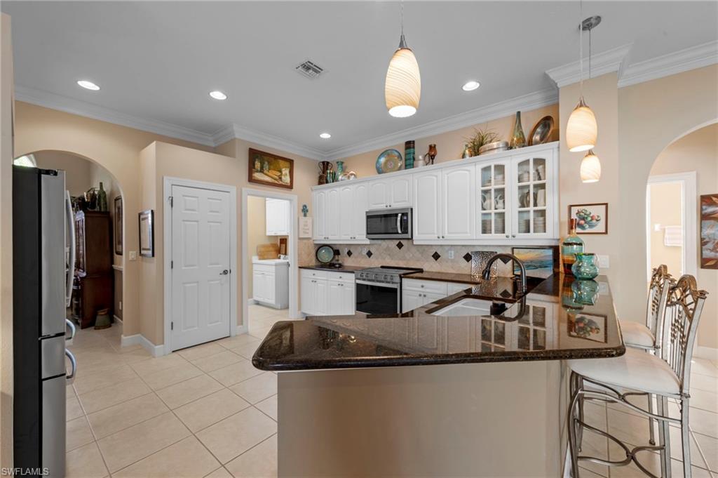 20042 Buttermere Court Estero, FL 33928 - Photo 18 of 47 a kitchen with stainless steel appliances granite countertop a sink and a refrigerator