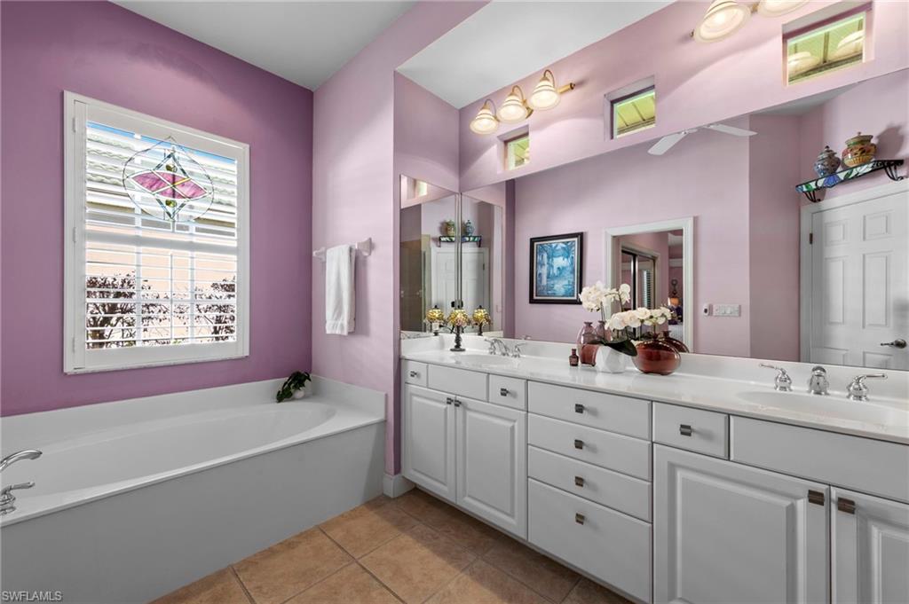 20042 Buttermere Court Estero, FL 33928 - Photo 30 of 47 a bathroom with a tub a sink and a large mirror