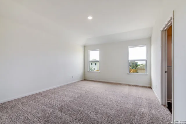 a view of an empty room with window and bathroom
