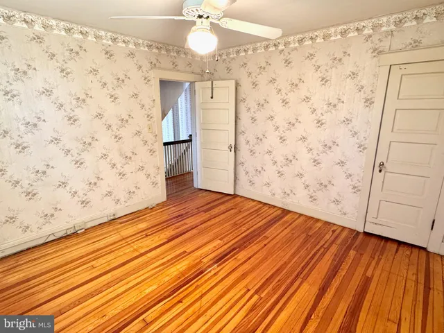 a view of a room with wooden floor and white walls